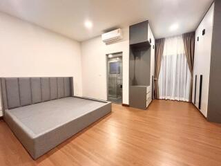 Modern bedroom with a gray sofa bed and wooden flooring