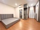 Modern bedroom with a gray sofa bed and wooden flooring