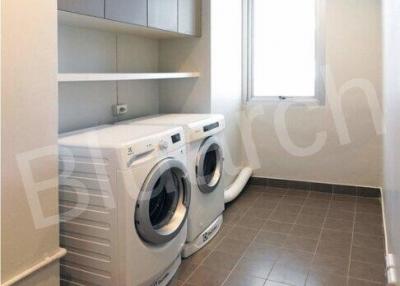 Compact laundry room with modern appliances and ample storage
