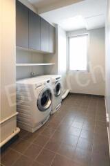 Compact laundry room with modern appliances and ample storage