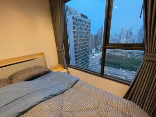 Cozy bedroom with a large window offering a city view