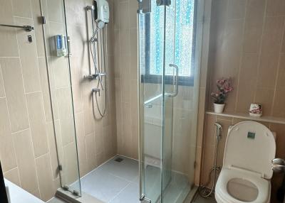 Modern bathroom with glass shower and beige tiles