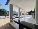 Spacious tiled patio with outdoor kitchen area and an adjacent playground