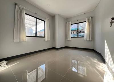 Bright and spacious tiled living room with large windows and curtains