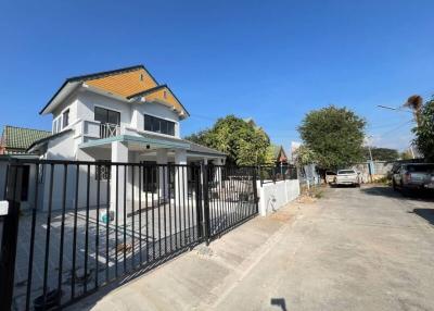 Exterior view of a modern two-story house with a gated entrance