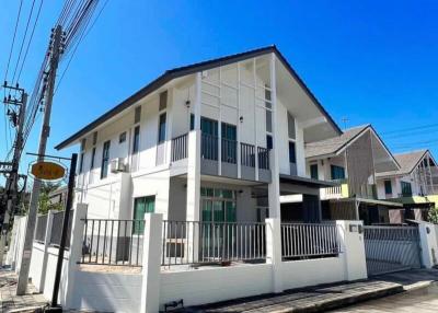 Modern two-story house with balcony under clear blue sky