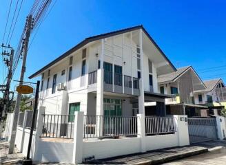 Modern two-story house with balcony under clear blue sky