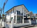 Modern two-story house with balcony under clear blue sky