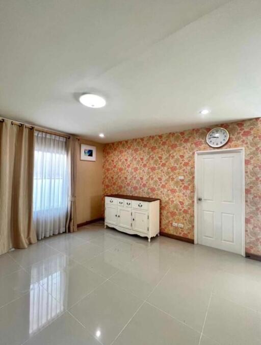 Spacious and brightly lit building interior with patterned wallpaper and tiled flooring