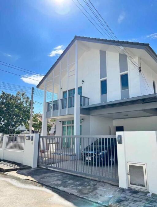 Modern two-story residential home with a balcony and gated entrance