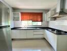 Modern kitchen with white cabinetry and natural light