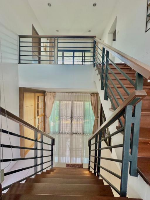 Modern staircase with wooden steps and metal railings inside a bright home