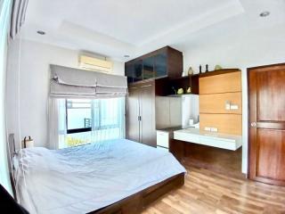 Modern bedroom with balcony access, built-in wardrobes, and hardwood flooring