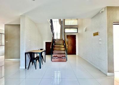 Spacious living area with staircase and dining table