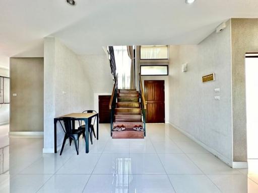 Spacious living area with staircase and dining table