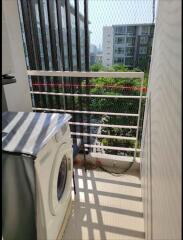 Compact balcony with a washing machine and a view of the surrounding buildings