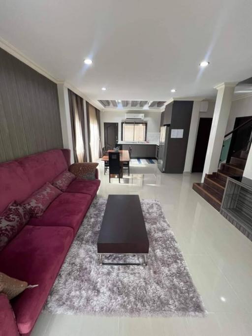 Spacious modern living room with a sectional sofa and open layout leading to the kitchen