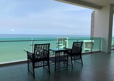 Spacious balcony with ocean view featuring a dining set