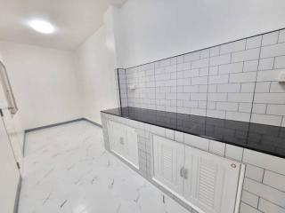 Modern kitchen with white cabinetry and tiled backsplash