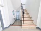 Modern staircase with wooden steps leading to the upper floor alongside a small bathroom