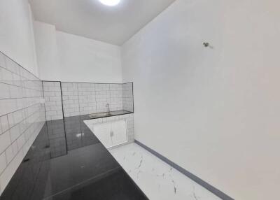 Modern white-tiled bathroom with a walk-in shower and white vanity