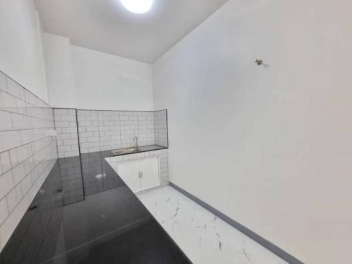 Modern white-tiled bathroom with a walk-in shower and white vanity