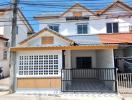 Exterior view of a two-storey residential house with white and brown color scheme