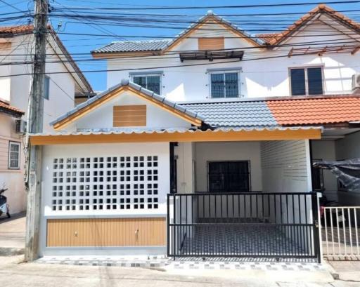 Exterior view of a two-storey residential house with white and brown color scheme