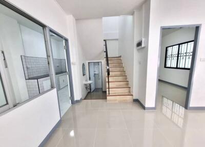 Spacious hallway with staircase and tiled flooring