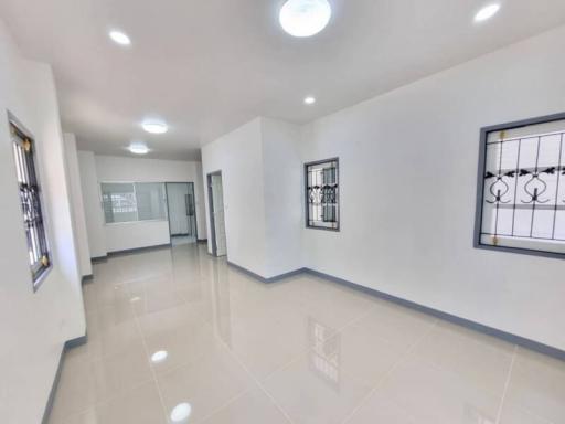 Spacious and well-lit living room with tiled flooring and stylish windows