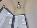 Bright hallway with modern light fixture and high ceiling