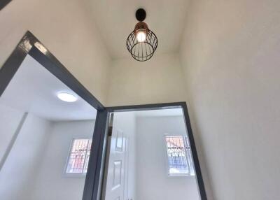 Bright hallway with modern light fixture and high ceiling