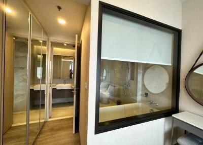 Modern bedroom interior with attached bathroom visible through the glass partition