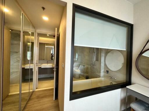 Modern bedroom interior with attached bathroom visible through the glass partition