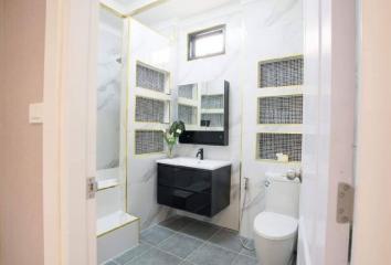 Modern bathroom interior with glass shower area, vanity, and tiled flooring