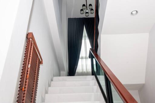 Modern home interior showcasing a staircase with wooden handrails and white steps