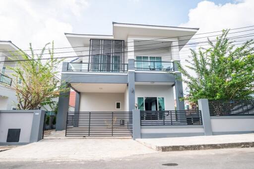 Modern two-story house with balcony and enclosed front yard