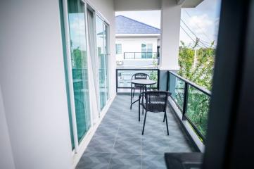 Spacious balcony with outdoor furniture and a view of residential area