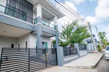 Modern two-story house with a gated entrance and driveway