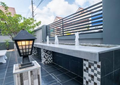 Modern outdoor patio with decorative water fountain and stylish lighting