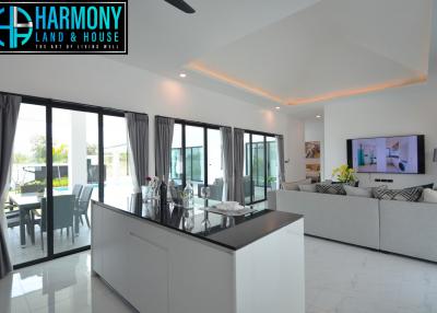 Spacious open-concept living room with modern kitchen, abundant natural light, and contemporary furnishings