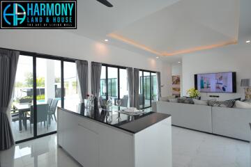 Spacious open-concept living room with modern kitchen, abundant natural light, and contemporary furnishings