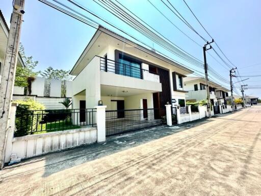 Modern two-story house with white facade located in a residential area