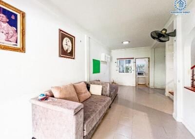 Spacious and brightly lit living room with comfortable seating and tiled flooring