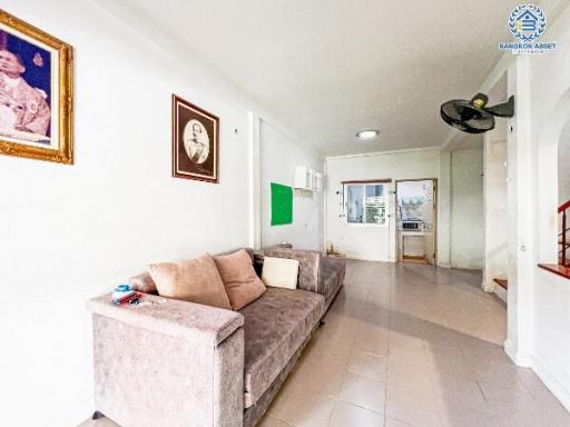 Spacious and brightly lit living room with comfortable seating and tiled flooring