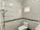 Modern bathroom with marble tiles and essential fittings
