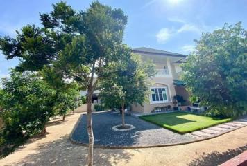 Spacious front yard of a suburban house with lush greenery under a clear blue sky