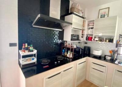 Modern kitchen with white cabinets and dark backsplash