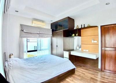 Spacious bedroom with large bed, modern furniture, and balcony access