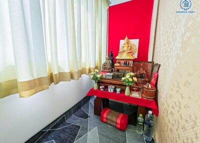 Spiritual altar with Buddha statue and offerings in a living space